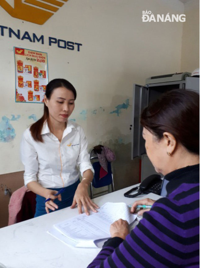 Chị Đinh Thị Ngọc Lan, nhân viên bưu điện xã Hòa Phước chi trả tiền  trợ cấp ưu đãi tại bưu điện cho người dân.