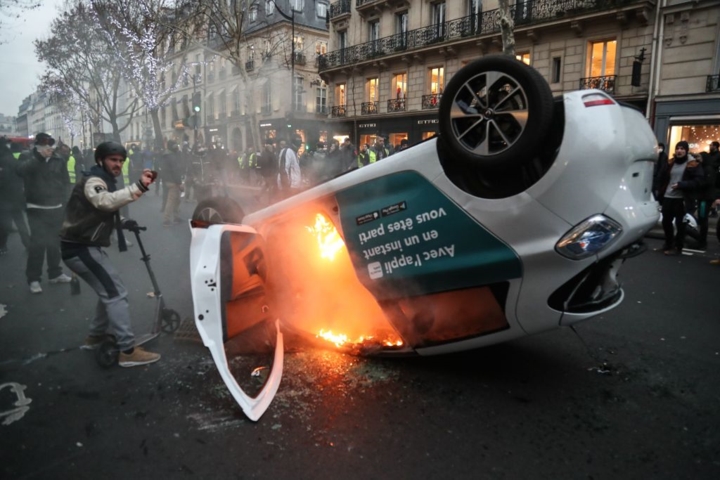 Một chiếc ô tô bốc cháy trên đường phố Paris ngày 5/1 trong cuộc đụng độ giữa phe Áo vàng chống chính phủ và lực lượng an ninh. 