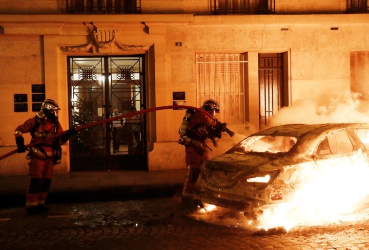 Lực lượng cứu hỏa đang cố gắng dập lửa một chiếc ô tô đang bốc cháy trên đường phố Paris. Bộ trưởng Nội vụ Pháp Christophe Castaner ước tính khoảng 50.000 người đã tham gia vào cuộc biểu tình ngày 5/1. 