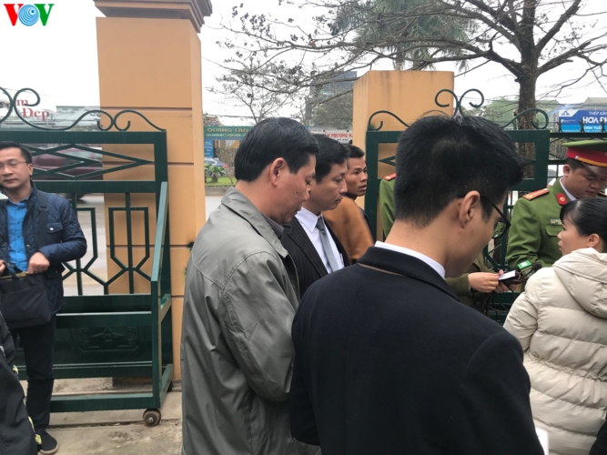 Bị cáo Trương Quý Dương (áo xám, nguyên giám đốc Bệnh viện đa khoa tỉnh Hòa Bình) đang làm thủ tục tham dự phiên tòa.