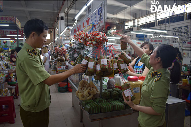 Lực lượng Quản lý thị trường kiểm tra hàng hóa tại chợ Hàn vào sáng 9-1. Ảnh: KHÁNH HÒA