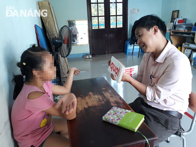 Thầy giáo Nguyễn Xuân Việt đang dạy giờ giáo dục cá nhân cho một học sinh mắc hội chứng khó đọc.  Ảnh: H.T