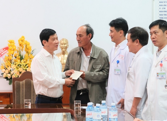 Deputy Minister Son presenting a gift to a relative of patient Ngo Thi Su Sal