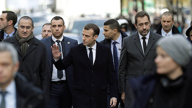 Tổng thống Pháp Emmanuel Macron (giữa) trong một chuyến thị sát các tuyến phố ở Paris, nơi xảy ra các cuộc biểu tình bạo loạn của phong trào “áo vàng”. 		Ảnh: AFP