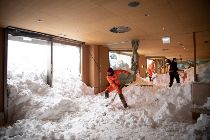 Các nhân viên cứu hộ đang dọn dẹp tuyết tại một khách sạn ở Thụy Sĩ sau khi tuyết lở khiến 3 người ở đây bị thương nhẹ. Ảnh: AP