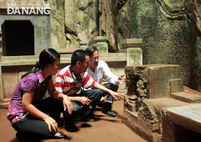  ThS. Tô Lan và ThS Quang Thắng (từ trái qua) khảo sát một phù điêu Chămpa trong động Huyền Không ngày 24-7-2010. Ảnh: V.T.L