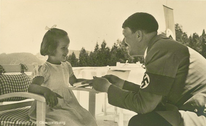 Trùm phát xít Đức Adolf Hitler mỉm cười làm thân với một cô bé.