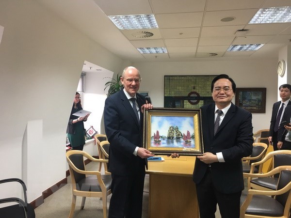 Vietnamese Minister of Education and Training Phung Xuan Nha (R) presents a gift to Minister of State at the UK Department for Education Nick Gibb (Photo: VNA)