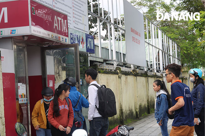 Nhiều người dân phản ánh gặp sự cố khi rút tiền ở các cây ATM. Trong ảnh: Khách hàng chờ rút tiền ở cây ATM của Agribank trên đường Tôn Đức Thắng. Ảnh: Văn Hoàng
