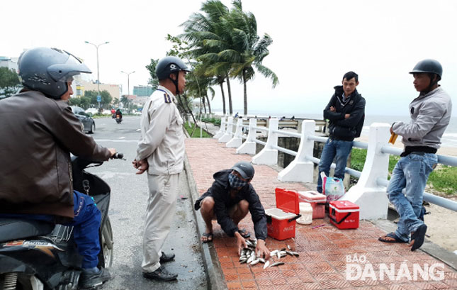 Lực lượng Quy tắc đô thị quận Thanh Khê nhắc nhở người dân không được buôn bán cá trên cầu Phú Lộc.