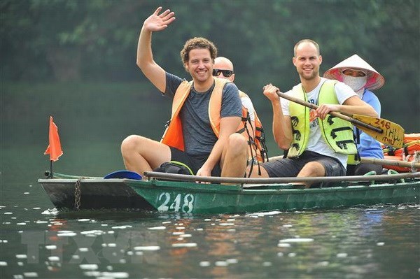 Foreign tourists in a boat tour around Trang An Complex, Ninh Binh province (Photo: VNA)