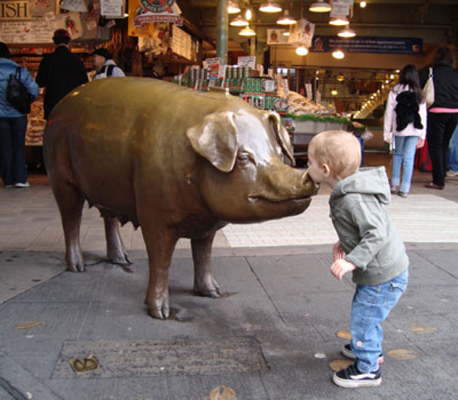  Trẻ em vui chơi với chú lợn bằng đồng ở khu chợ Pike Place Seattle, Hoa Kỳ.