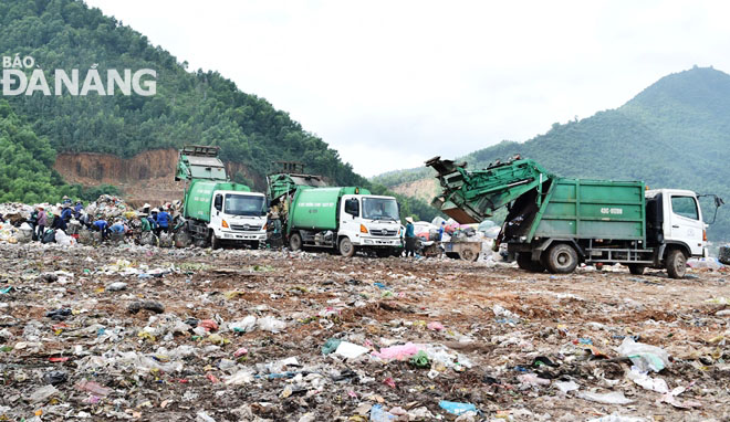 Xe vận chuyển nối đuôi nhau đưa rác thải sinh hoạt từ đường phố lên bãi rác Khánh Sơn. Ảnh: HOÀNG HIỆP
