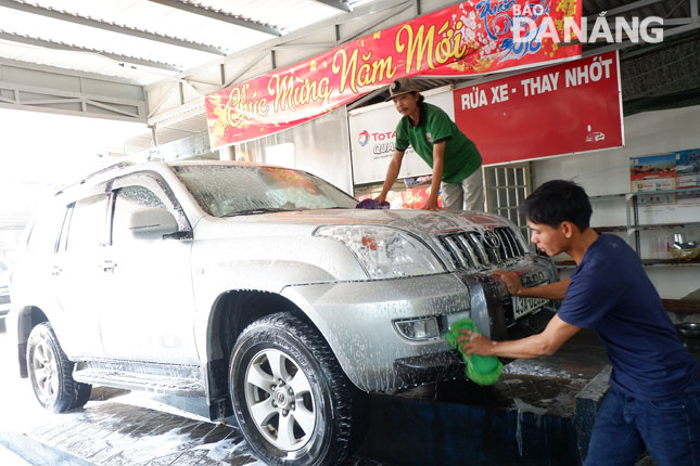 Nhân viên tại Gara ô tô Bến Thành 2 (32B Tiểu La, quận Hải Châu) đang rửa xe cho khách.