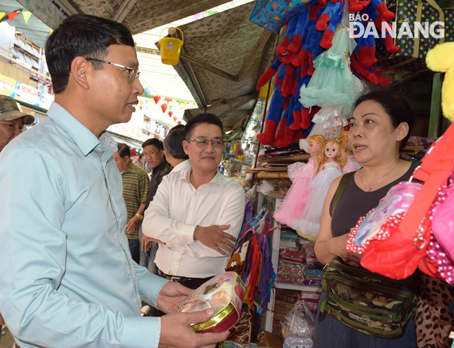 Phó Chủ tịch UBND thành phố Hồ Kỳ Minh (bìa trái) trò chuyện và đề nghị các hộ tiểu thương bán đúng giá theo niêm yết và chú ý bảo đảm an toàn phòng cháy chữa cháy,