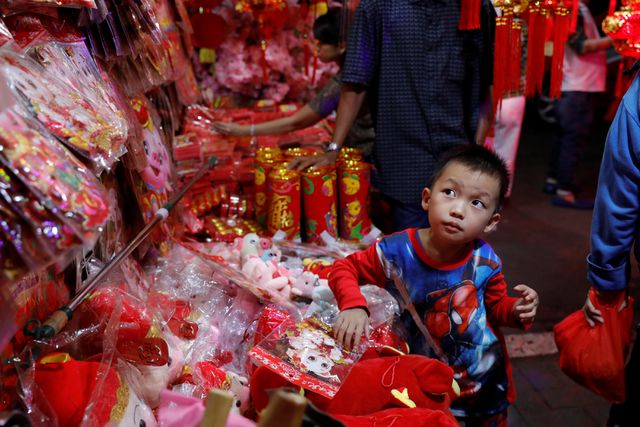 Một em nhỏ đứng tại quầy hàng đồ Tết tại một khu chợ truyền thống ở thủ đô Jakarta, Indonesia. (Ảnh: Reuters)