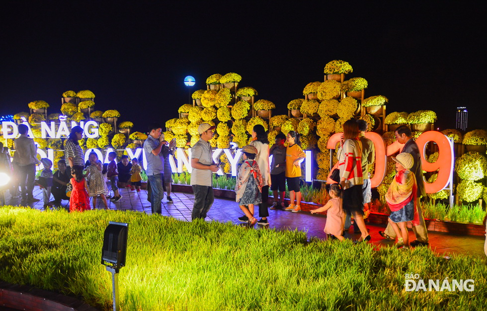 The Bach Dang Spring Flower Street has attracted a large number of people and they have become involved in taking photos to save their memorable moments with beautiful floral decorations.