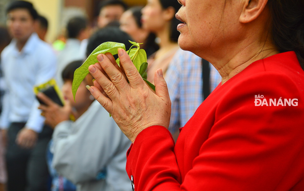 A woman is holding buds in order to pray for good lucks in the New Year