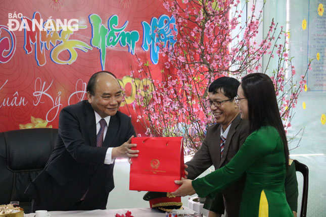 PM Phuc (first left) presenting a Tet gift to the authorities of Thuan Phuoc Ward.