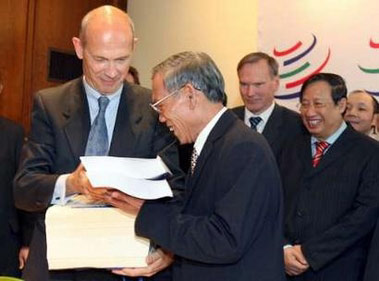 Tổng Giám đốc WTO Pascal Lamy và Bộ trưởng Thương mại Việt Nam Trương Đình Tuyển trao đổi văn kiện Nghị định thư gia nhập WTO của Việt Nam. Ảnh tư liệu TTXVN