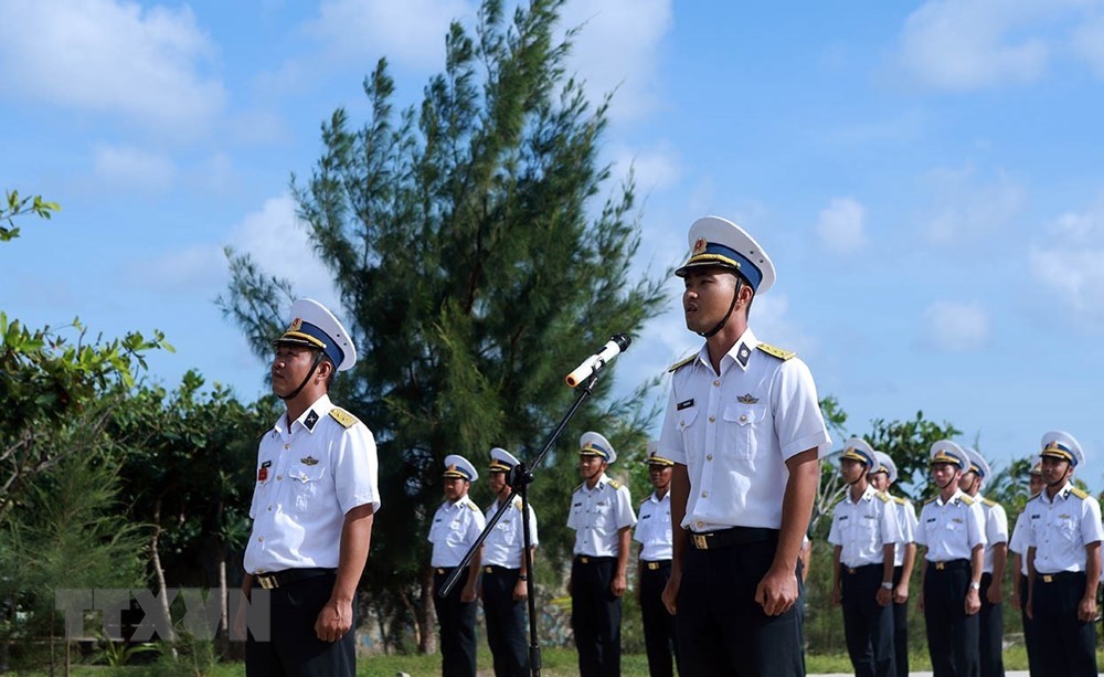 Thượng úy Mai Xuân Hải (bên phải ảnh) tuyên thệ 10 lời thề danh dự của quân nhân Quân đội nhân dân Việt Nam tại lễ chào cờ, duyệt đội ngũ tại đảo Trường Sa Đông (quần đảo Trường Sa). (Ảnh: Hoàng Hùng/TTXVN)
