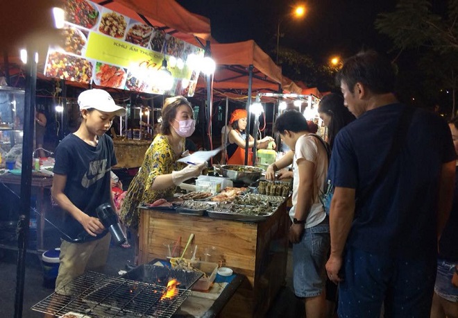 Some South Korean visitors enjoying grilled seafood at the Son Tra Night Market