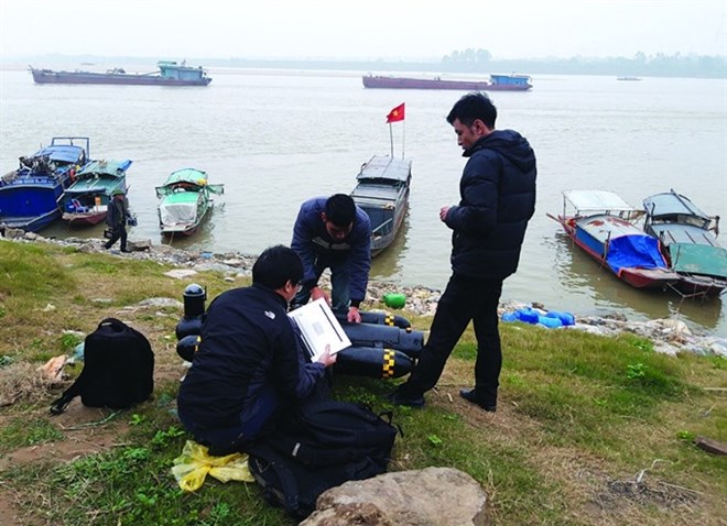 Researchers from the ViInstitute of Geodesy and Cartography prepare to test their seafloor mapping vehicle by the Hong (Red) River. The unmanned surface vehicles, developed in Vietnam, can gather data from areas of the ocean floor and river beds inaccessible to humans. (Photo: baotainguyenmoitruong.vn)