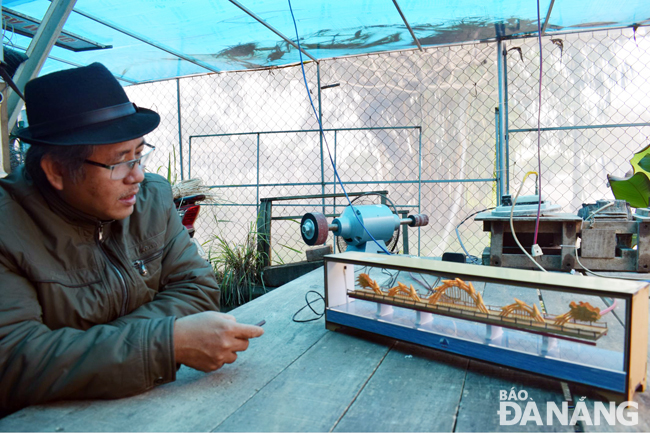 Director Phieu and his wooden Dragon Bridge model.