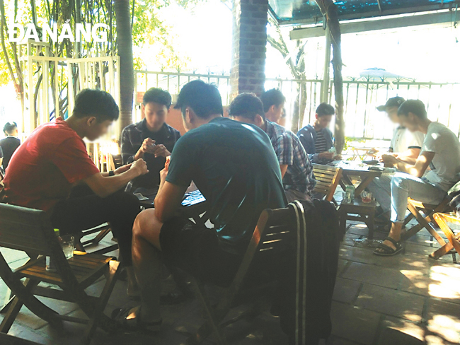 Một số thanh niên đánh bài tại một quán cà-phê trên đường Hà Văn Tính.