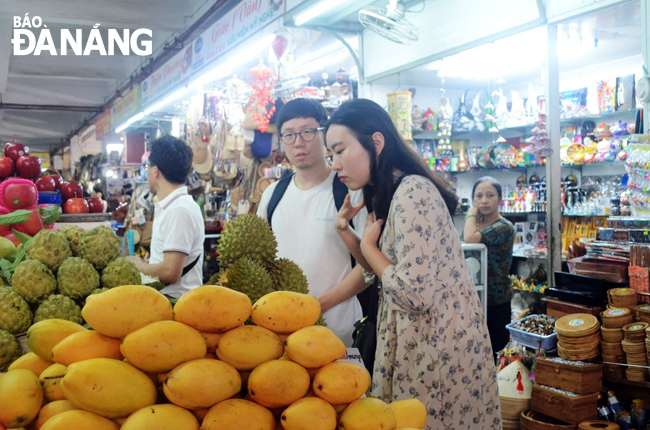 Các sản phẩm trái cây tươi, sấy khô được nhiều khách du lịch tàu biển ưa chuộng.  TRONG ẢNH: Du khách mua sắm tại chợ Hàn.