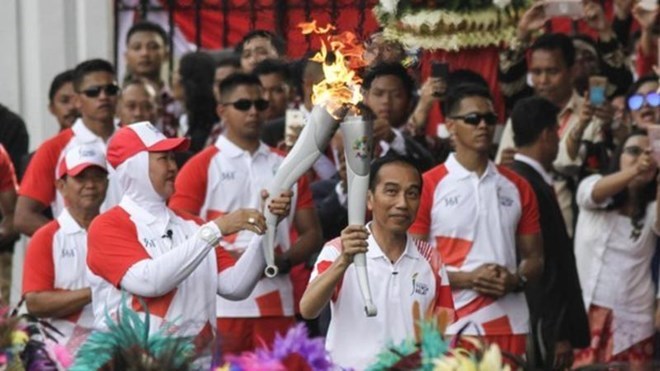 Indonesian President Joko Widodo (front, right) carries a torch of the 2018 Asian Games (Photo: BBC)