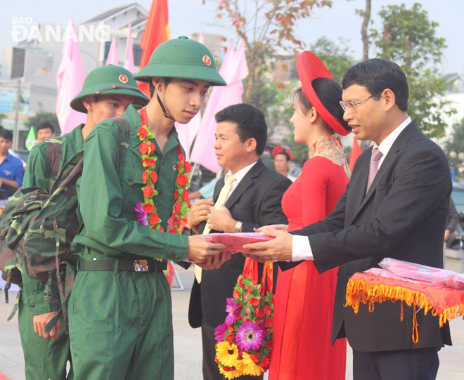 Phó Chủ tịch UBND thành phố Hồ Kỳ Minh tặng hoa chúc mừng các tân binh tại điểm giao nhận quân quận Liên Chiểu. Ảnh: THU THẢO