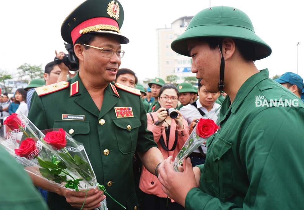 Trung tướng Trần Quang Phương, Chính ủy Quân khu 5 tặng hoa chúc mừng các tân bịnh tại điểm giao - nhận quân quận Hải Châu. ảnh: PHAN CHUNG