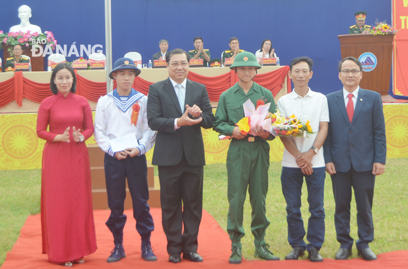 Municipal People’s Committee Chairman Huynh Duc Tho (3rd left), along with leaders of Ngu Hanh Son District, presenting flowers and gifts to two siblings who wrote a letter to volunteer for military service. They are 24-year-old Nguyen Huu Binh and 19-year-old Nguyen Huu Thang, both residing in the district’s My An Ward.