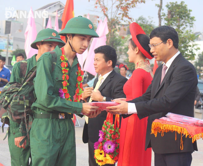 Vice Chairman Minh (right) giving flowers to recruits in Lien Chieu District.