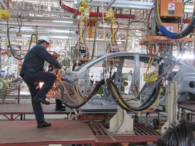 A worker welds a car body at TCIE Viet Nam’s Nissan Automobile factory in the Hoa Khanh Industrial Zone