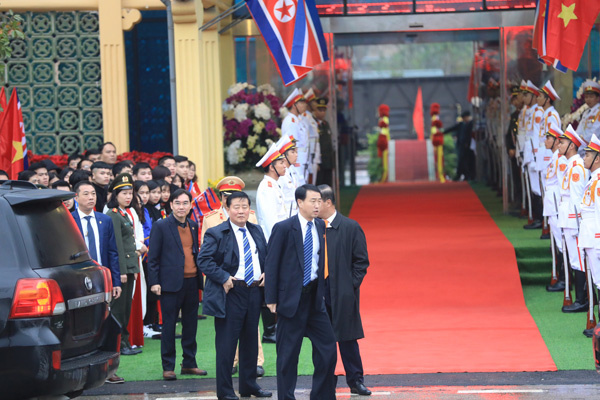 Sau khi bước xuống đoàn tàu bọc thép, nhà lãnh đạo Triều Tiên bắt tay chào hỏi đoàn lãnh đạo Việt Nam đang đứng thành hàng dài đón ông. Bên ngoài cổng ga, đội an ninh đã chờ sẵn. Ảnh: Hữu Khoa