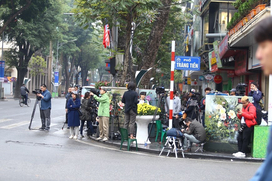 Phóng viên các hãng truyền thông quốc tế và báo chí trong nước tác nghiệp từ góc ngã tư Ngô Quyền-Tràng Tiền hướng sang phía khách sạn Metropole. (Ảnh: Minh Quyết/TTXVN)