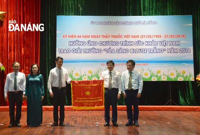 Authorised by the Prime Minister, Deputy Secretary Tri (second right) giving an emulation flag to the Da Nang General Hospital.