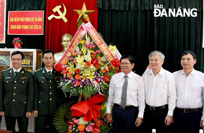 Phó Bí thư Thường trực Thành ủy Võ Công Trí (thứ 3, từ phải sang) tặng hoa chúc mừng cán bộ, chiến sĩ Trạm Biên phòng Cửa khẩu cảng Tiên Sa. 			          Ảnh: ĐẶNG NỞ