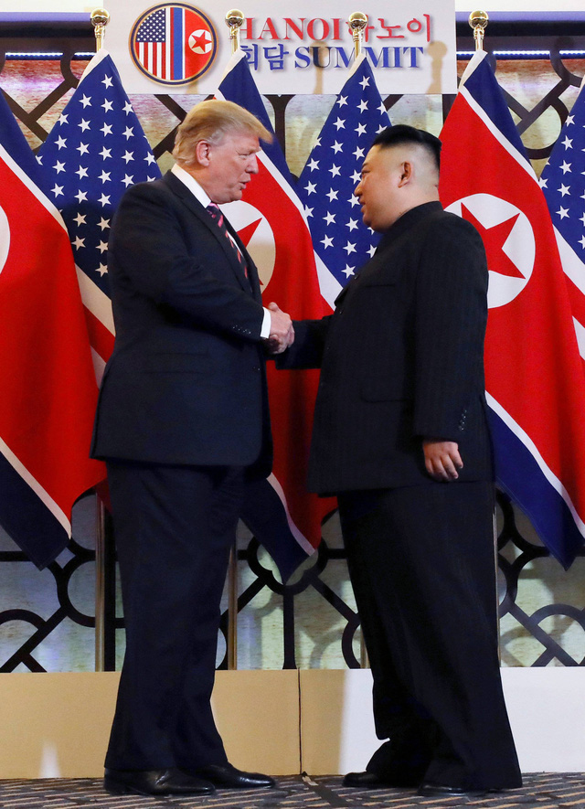 Tổng thống Mỹ Donald Trump và nhà lãnh đạo Triều Tiên Kim Jong-un bắt tay dưới dòng chữ “Hanoi Summit”. 		Ảnh: Reuters