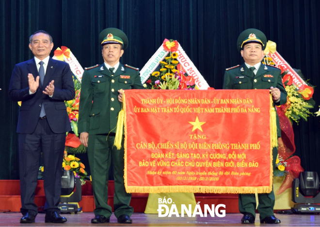Bí thư Thành ủy Trương Quang Nghĩa (bìa trái) tặng bức trướng của Thành ủy, HĐND, UBND, Ủy ban MTTQ Việt Nam thành phố cho Bộ Chỉ huy Bộ đội Biên phòng thành phố tại lễ kỷ niệm. Ảnh: HOÀNG HIỆP