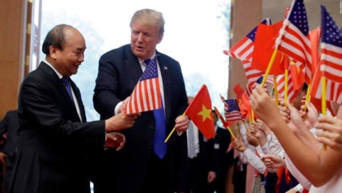 Tổng thống Donald Trump nhận lấy quốc kỳ hai nước và chia sẻ với Thủ tướng Nguyễn Xuân Phúc. Ảnh: CNN.