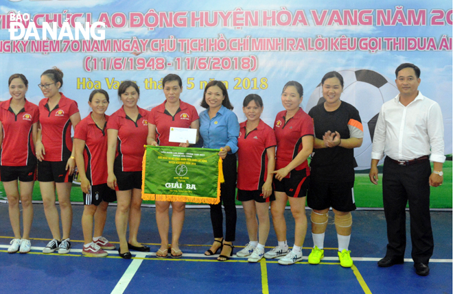 Chị Nguyễn Thị Do (thứ 5, phải qua) trao cờ cho đơn vị đoạt giải tại giải bóng đá nữ do Liên đoàn Lao động huyện Hòa Vang tổ chức.