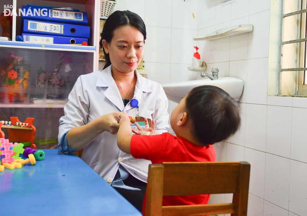 A medical worker caring for a child patient in the Da Nang Mental Health Hospital