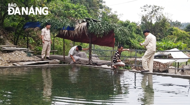 Lực lượng chức năng phường Hòa Hiệp Bắc giám sát ông Nguyễn Văn Dũng (thứ hai, từ phải qua) tự tháo dỡ hạng mục xây bờ kè chắn dòng chảy của suối Lương.