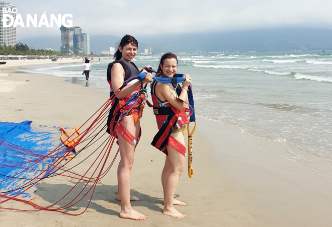 Two foreign reporters experiencing a water sport at a beach