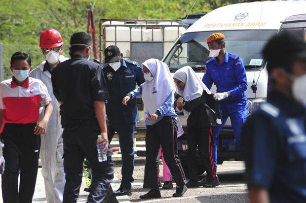 Emergency personnel help students school evacuate after toxic chemical spill in Pasir Gudang, Johor state on Wednesday. (AP Photo)