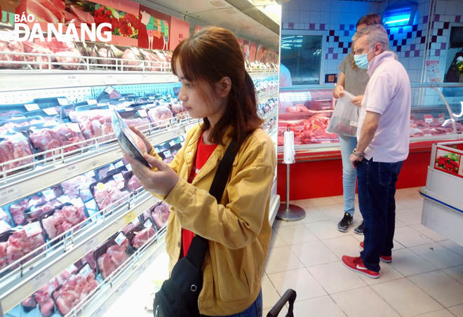 Shoppers buying pork meat at a supermarket