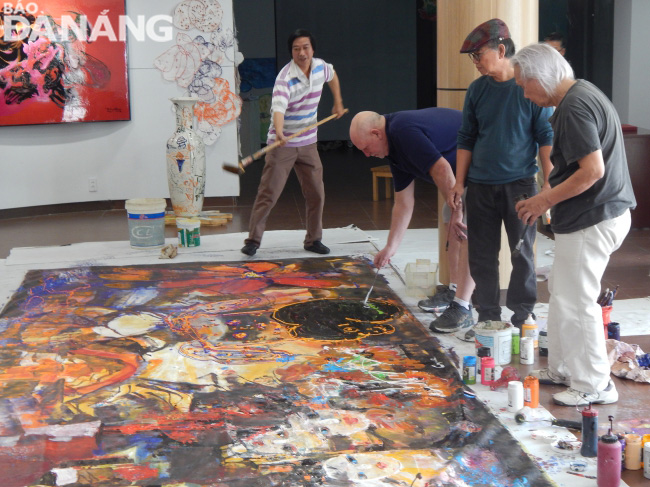 The artists jointly creating the 5m-long acrylic painting